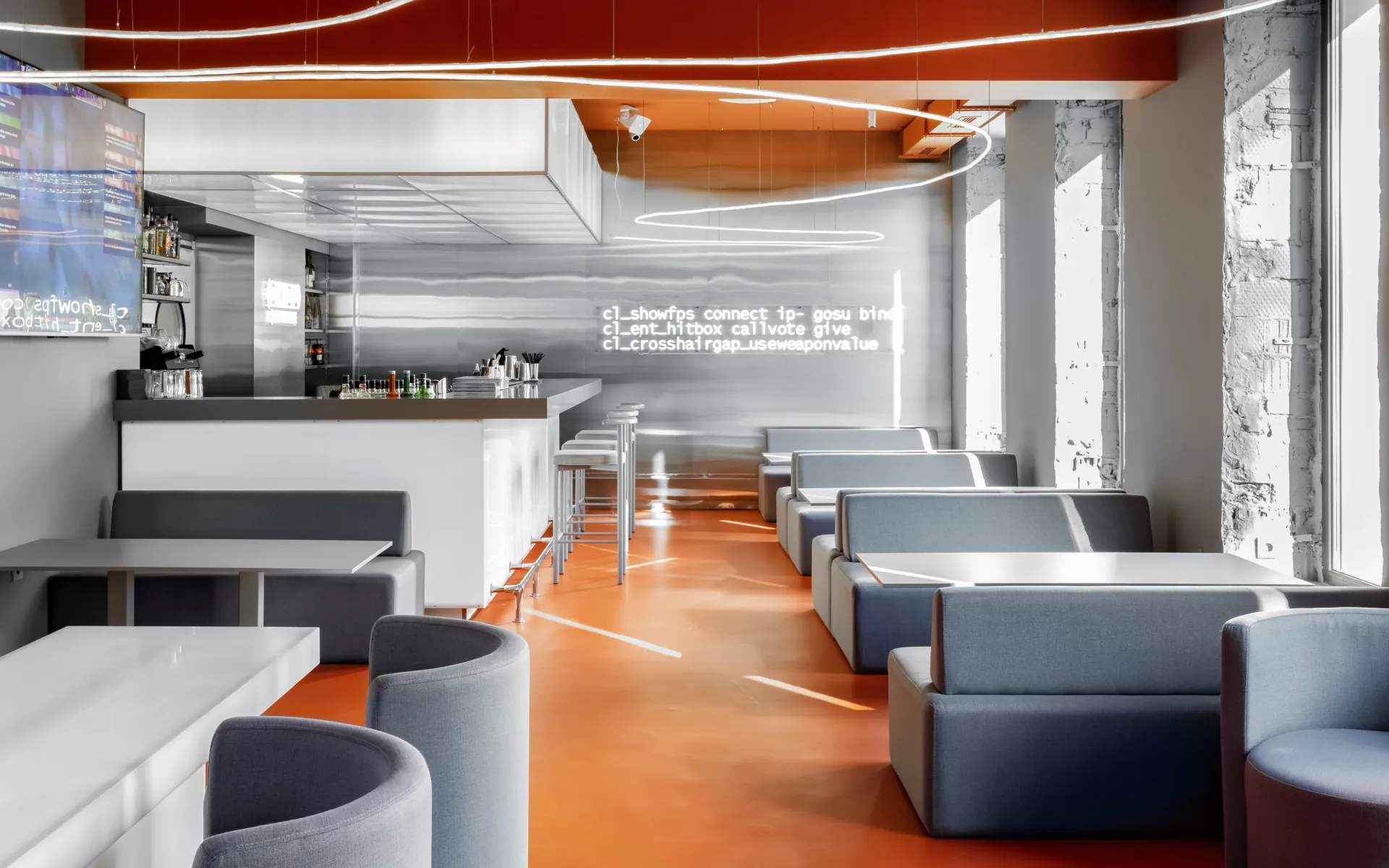 GOSU Cyber Lounge: bar with a white canopy, mirror-finish wall with lines of game-console text and an orange floor